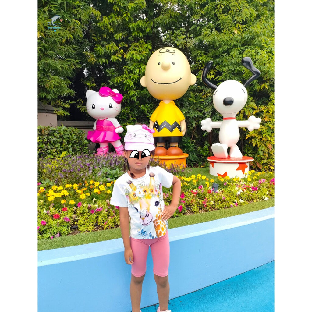 USJ通称ユニバのワンダーランドでキティちゃんとスヌーピーとチャーリーブラウンのオブジェと一緒にモデルポーズで写真を撮る子供